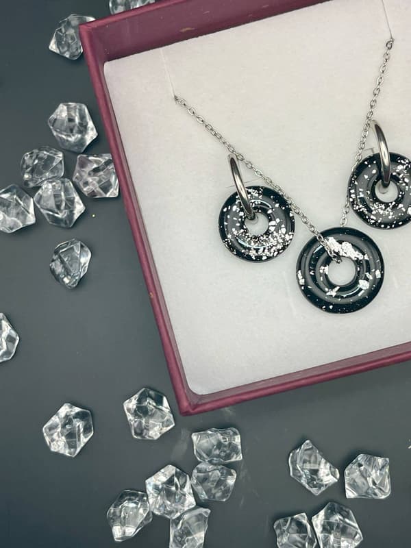 Detalle de pendientes y colgante hechos a mano con detalles brillantes y cierres de acero