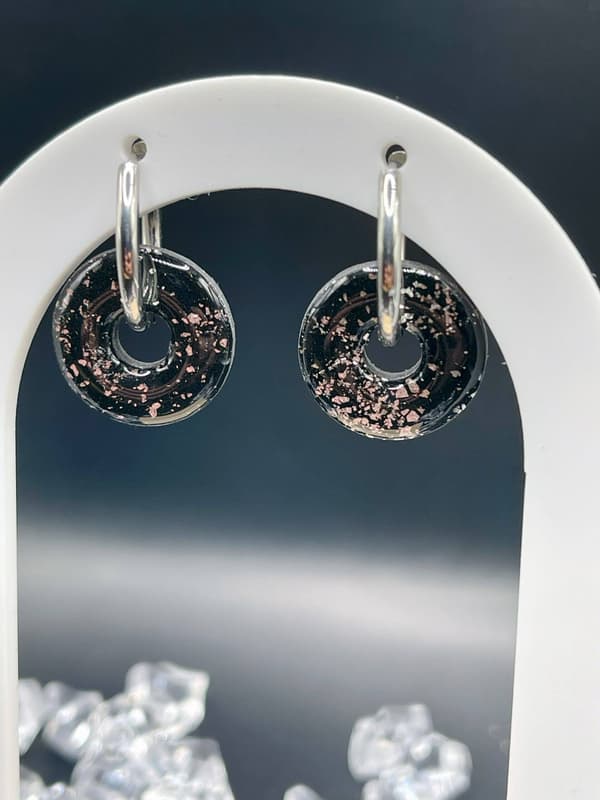 Detalle de los aros de acero con charm circular Nox hecho a mano