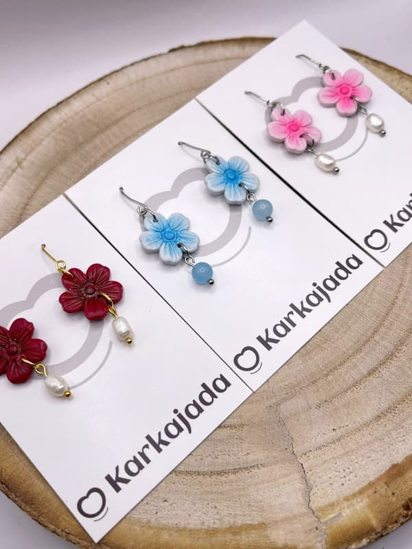 Detalle de los pendientes Lila Azul con flor modelada a mano y cuenta colgante