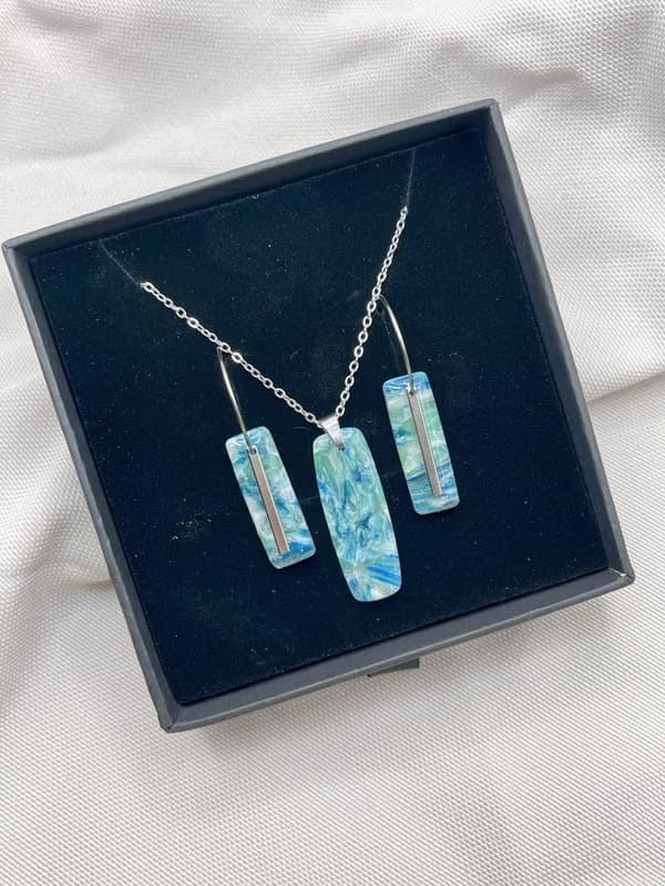 Set de pendientes y colgante Línea Mareas en caja, con arcilla polimérica azul y detalles de acero inoxidable
